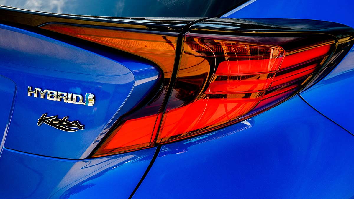 A blue Toyota C-HR Hybrid's taillight and logo