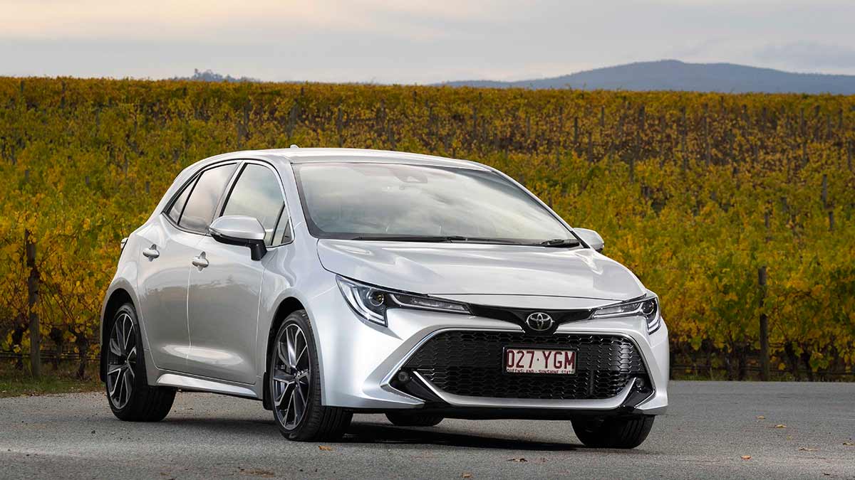 Front side view of a silver Toyota Corolla ZR parked on a highway in the countryside