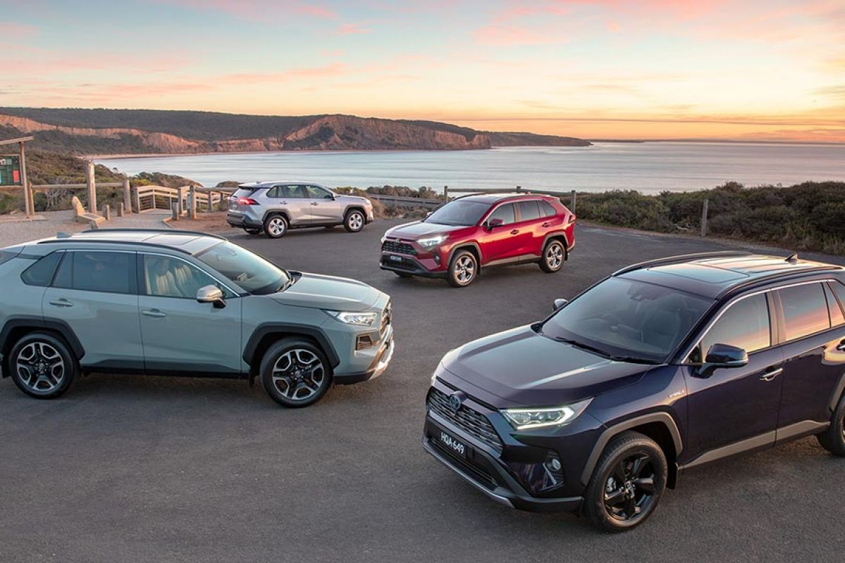 The Toyota RAV4 range on show by a beach.