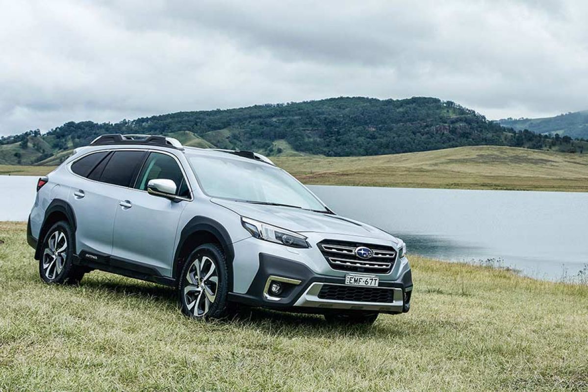 Silver Subaru Outback parked in front of lake