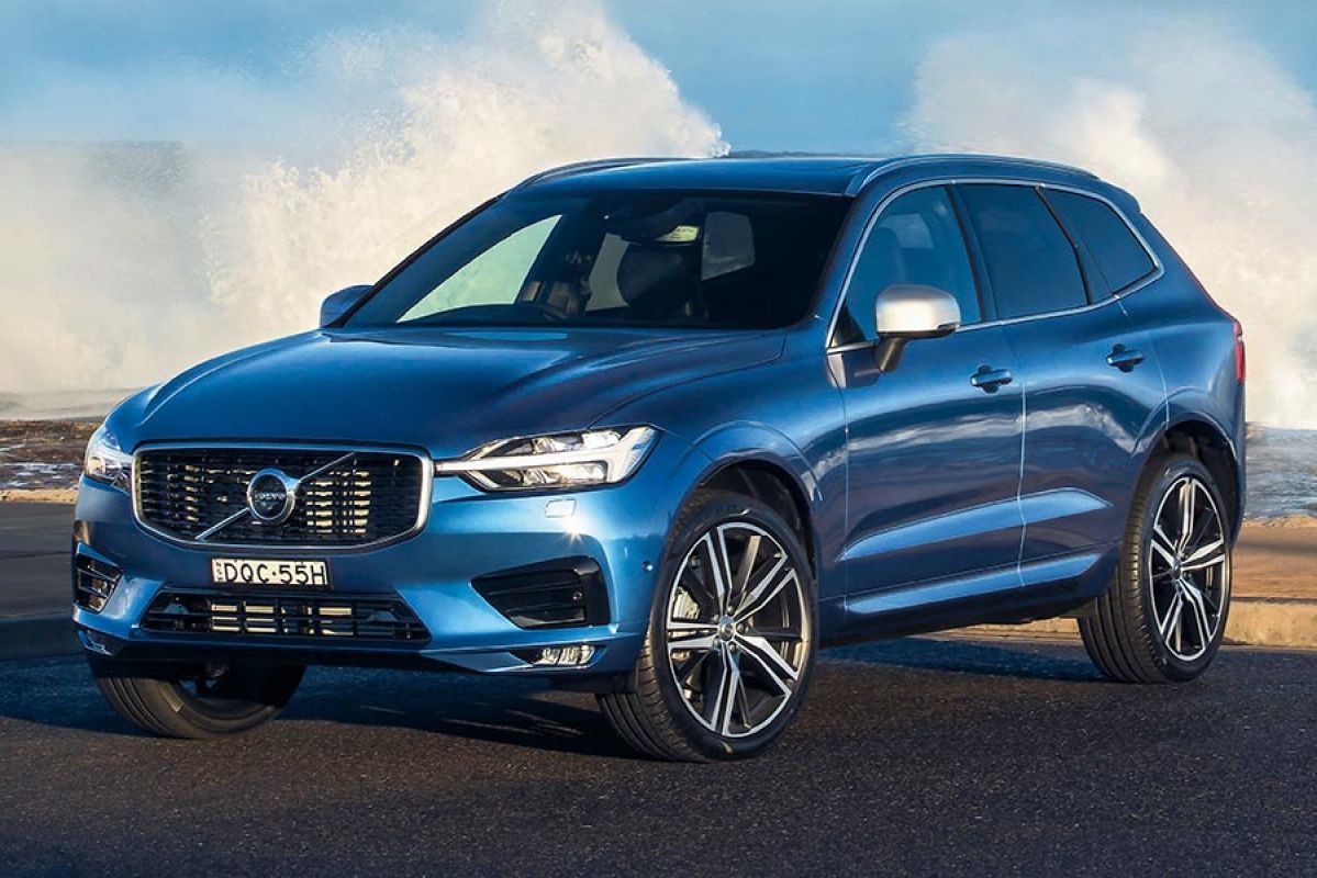 Front side view of a metallic blue Volvo XC60 2018 car parked next to the beach