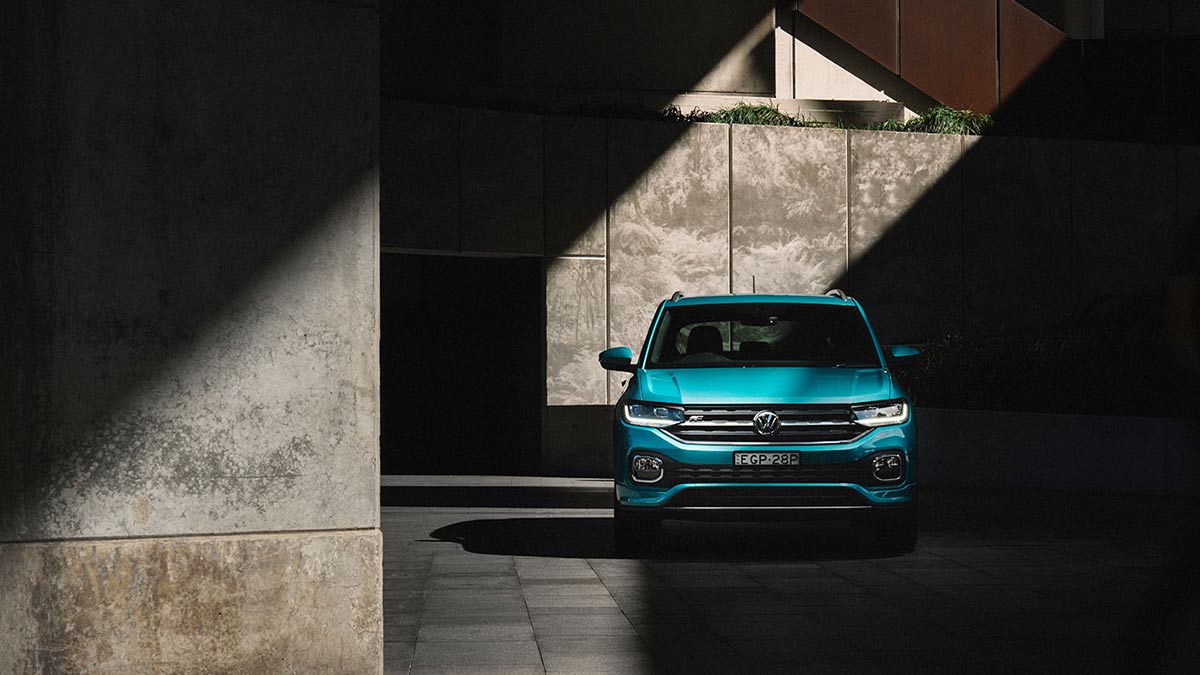 Front view of a turquoise Volkswagen T-Cross 85 TSI Style 2020 parked under a concrete structure