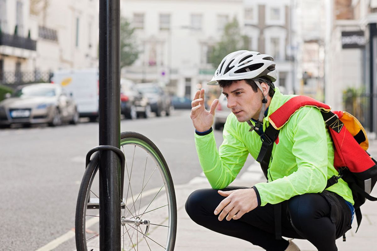 Man with helmet and hands on head after losing bike 