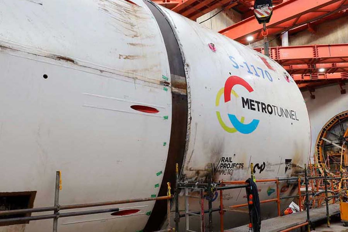 Large tunnel machine with city workers nearby.