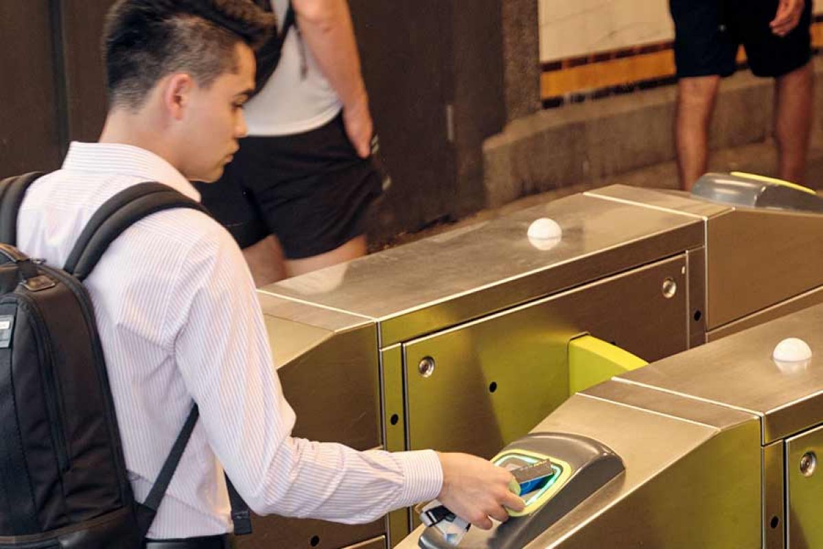 Man at station touching on with his Myki card.