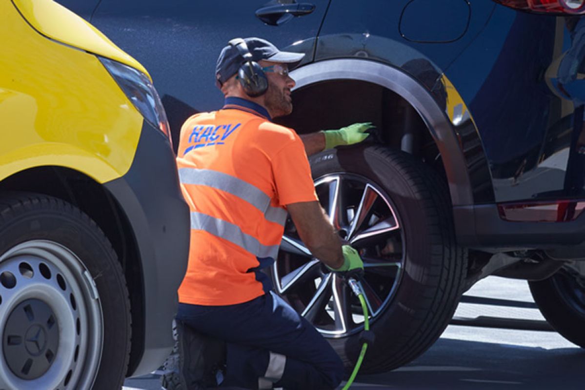 RACV emergency roadside assistant changing tyre on car