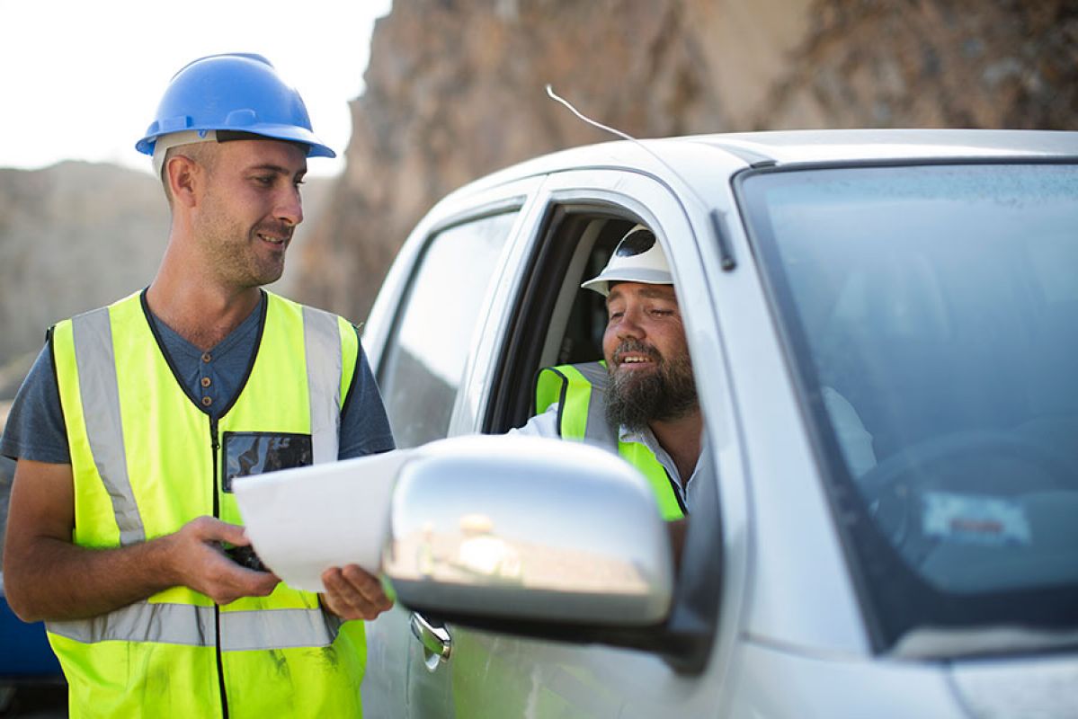 two men on worksite looking at documents