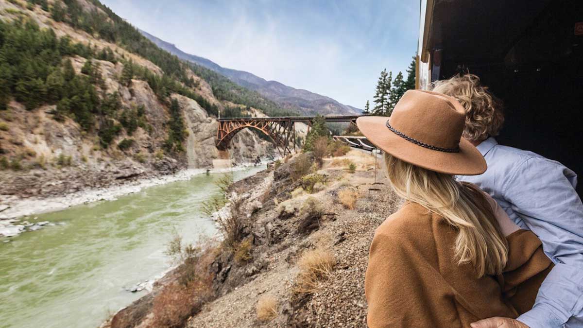 couple on a train in Canada rolling through the Rocky Mountains