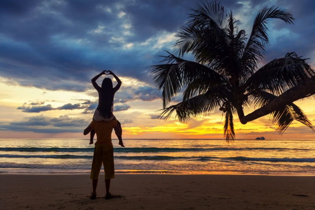 man and woman watching a tropical sunset