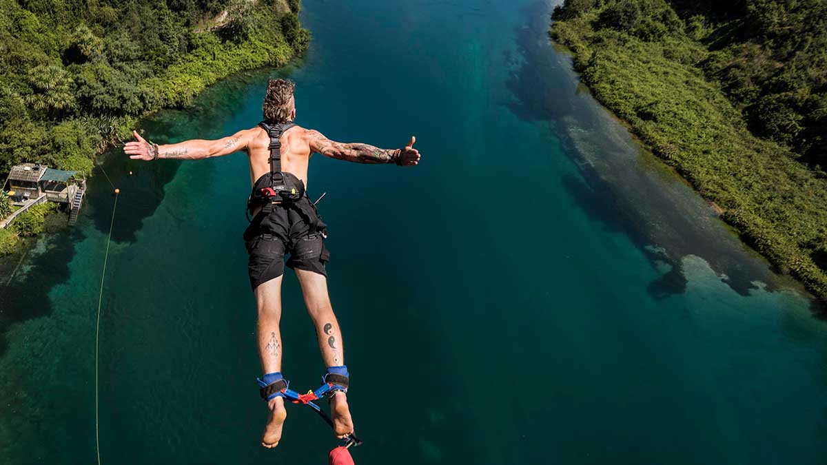 person bungy jumping over water