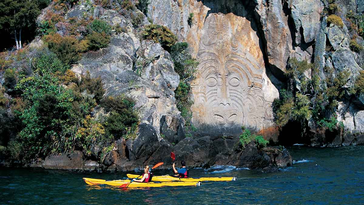 people paddling near cliffs