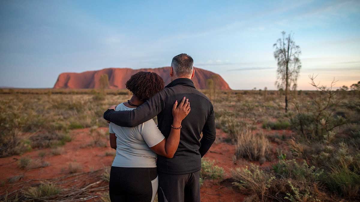 Couple embracing at Uluru during sunrise