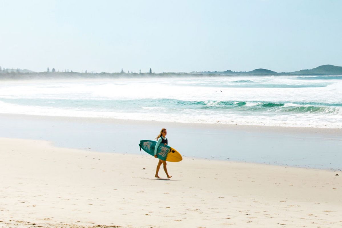 surfer walking on beach