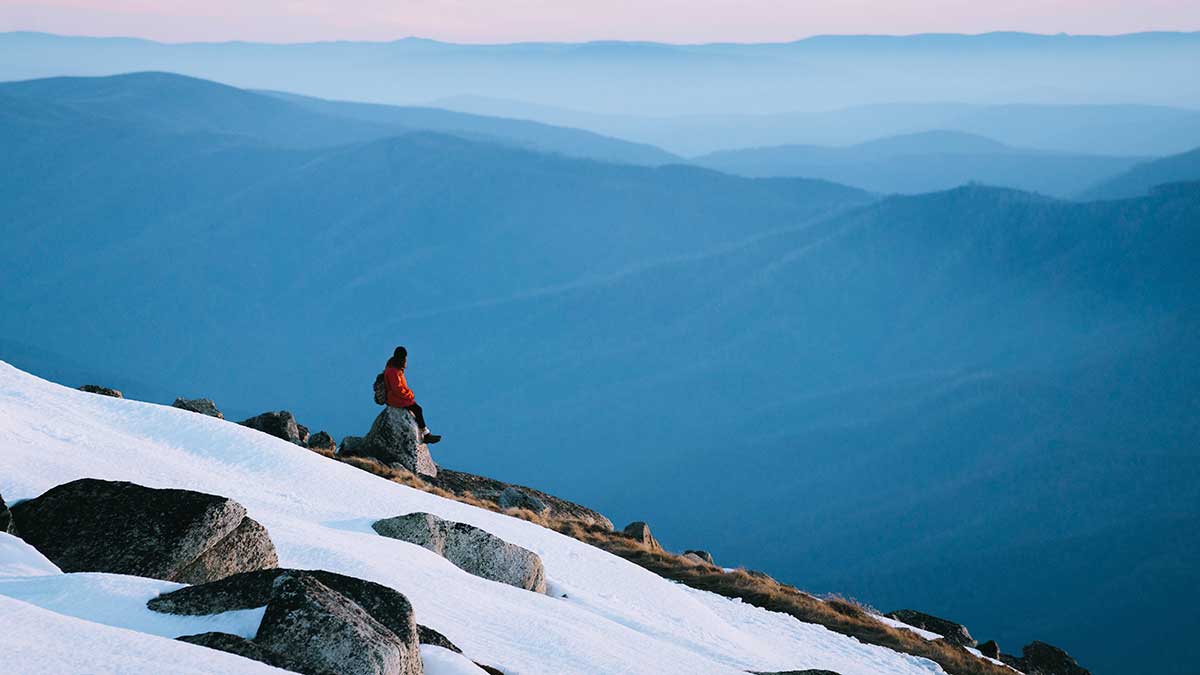 Man hiking up a snow covered mountain