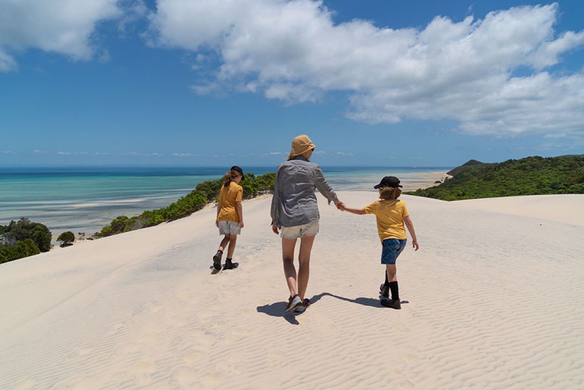 Young family enjoying a walk along a beach in Brisbane