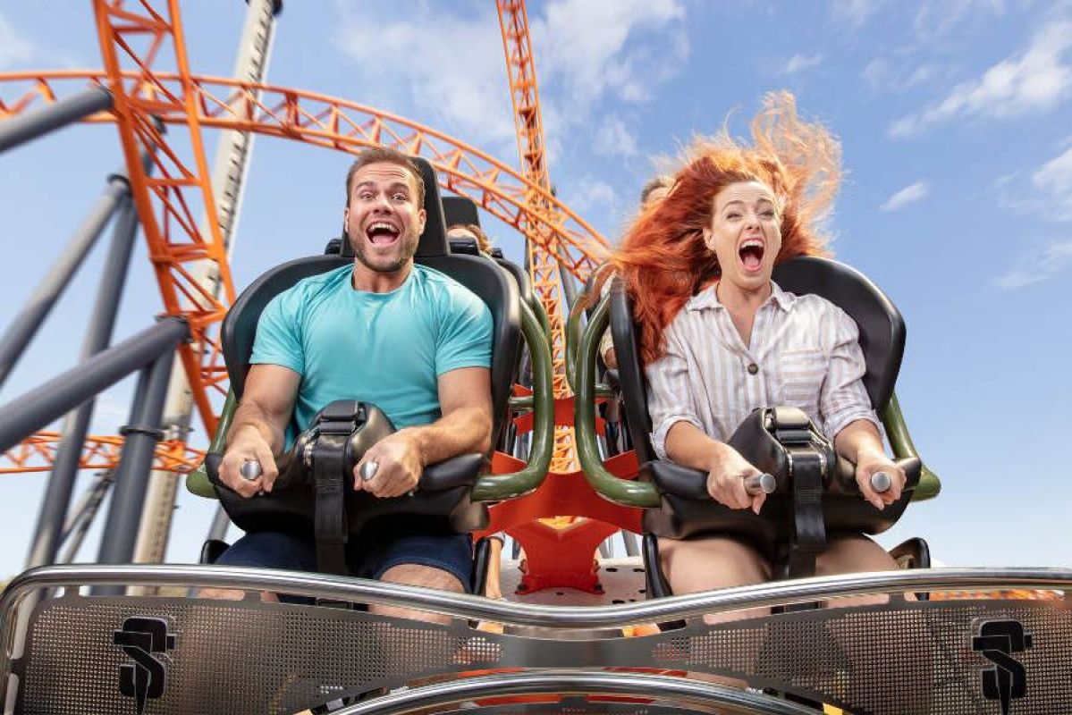 man and woman riding a rollercoaster at Dreamworld, screaming happily