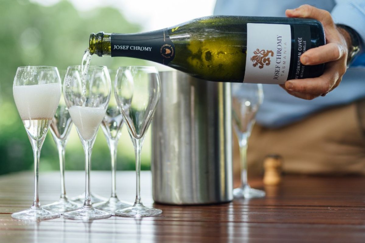 man pouring a Josef Chromy wine into glasses