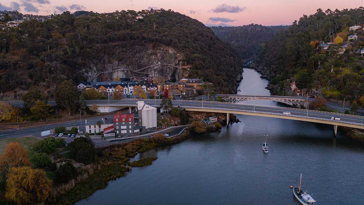 a bridge crossing a river at sunset