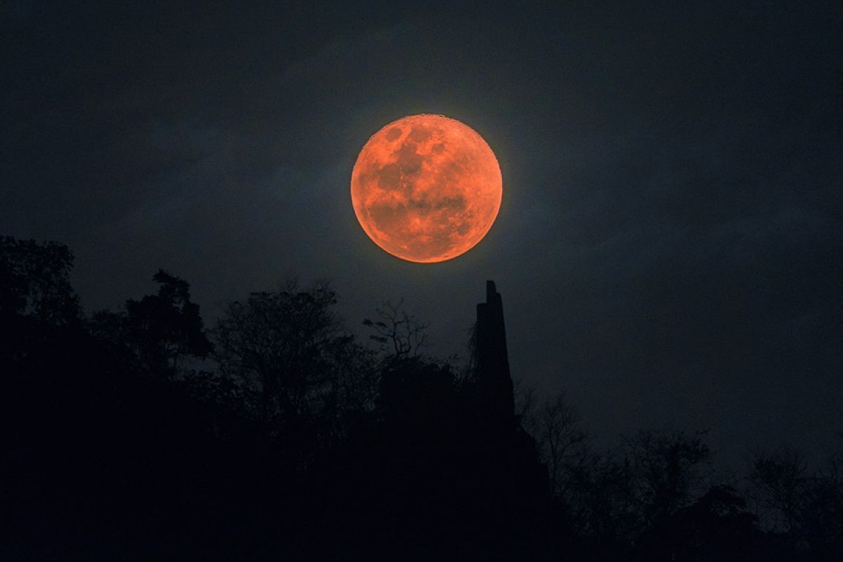 Red blood moon with an iridescent reddish hue in the night sky