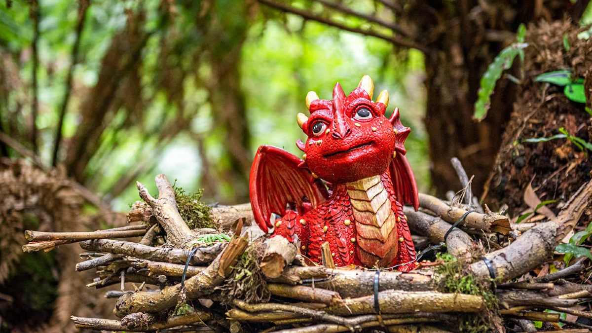 Red toy dragon in the forest