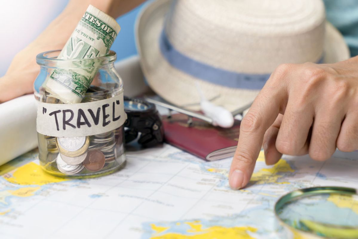 pointing to map with travel fund jar