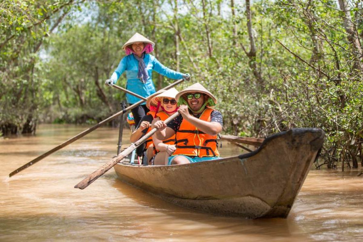 tourists being poled down the Vietnam Mekong delta through mangroves