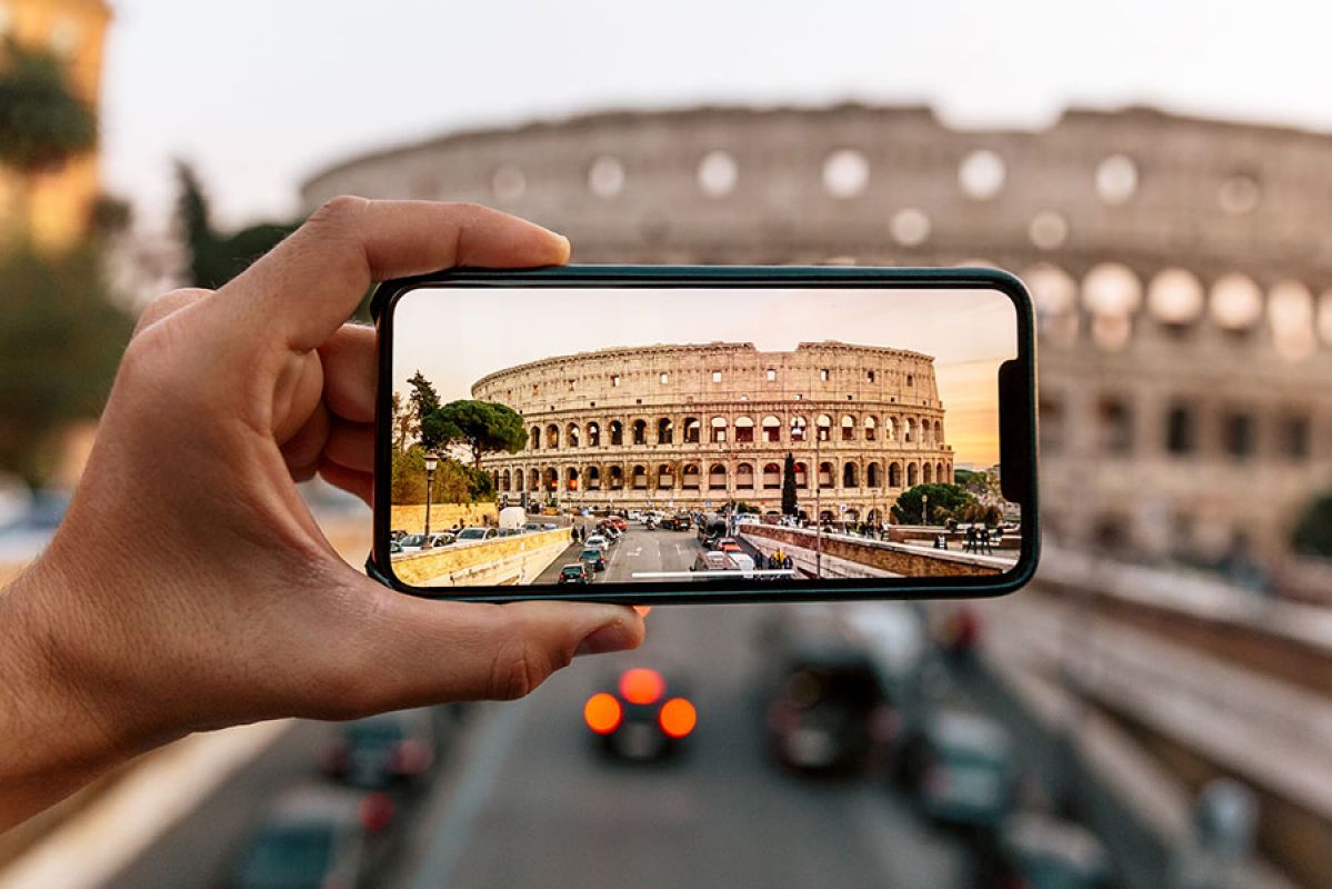 A person taking a photo of the Colosseum on a smartphone