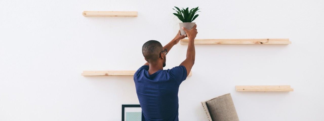 man installing floating shelves