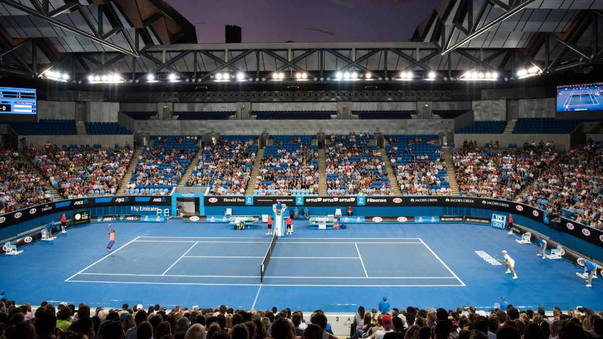people playing tennis in front of crowd at Margaret Court Arena