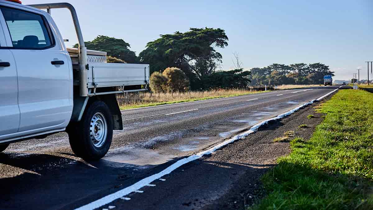 ute travelling on road with potholes