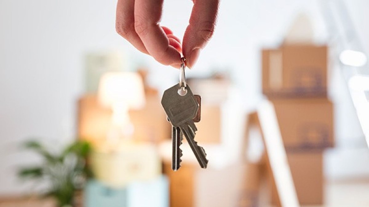 hand holding house keys in living room