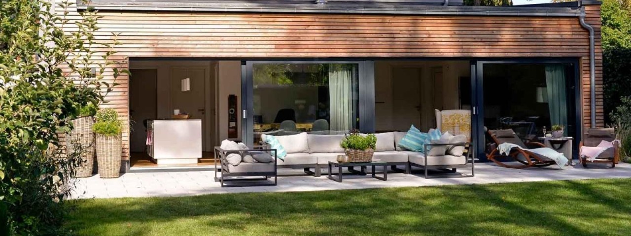 backyard lawn of two storey property with open sliding doors