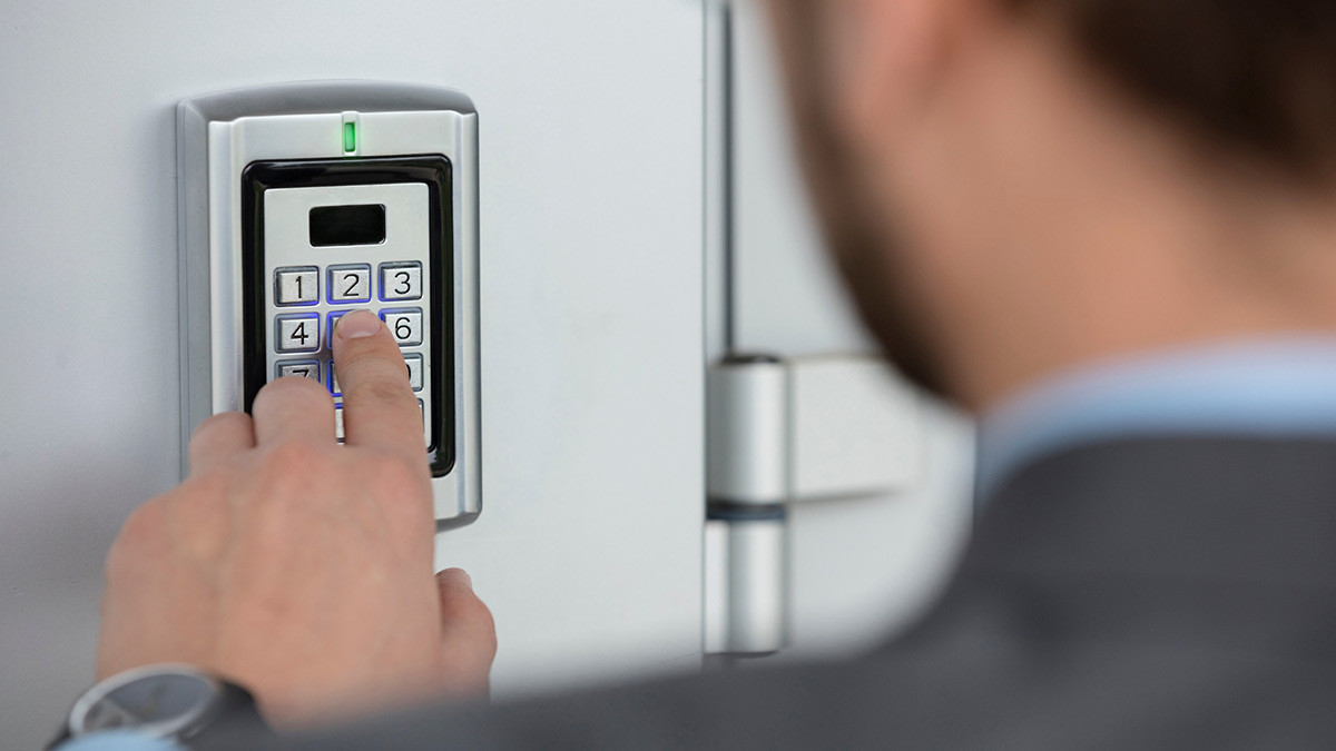 Man entering code on keypad lock