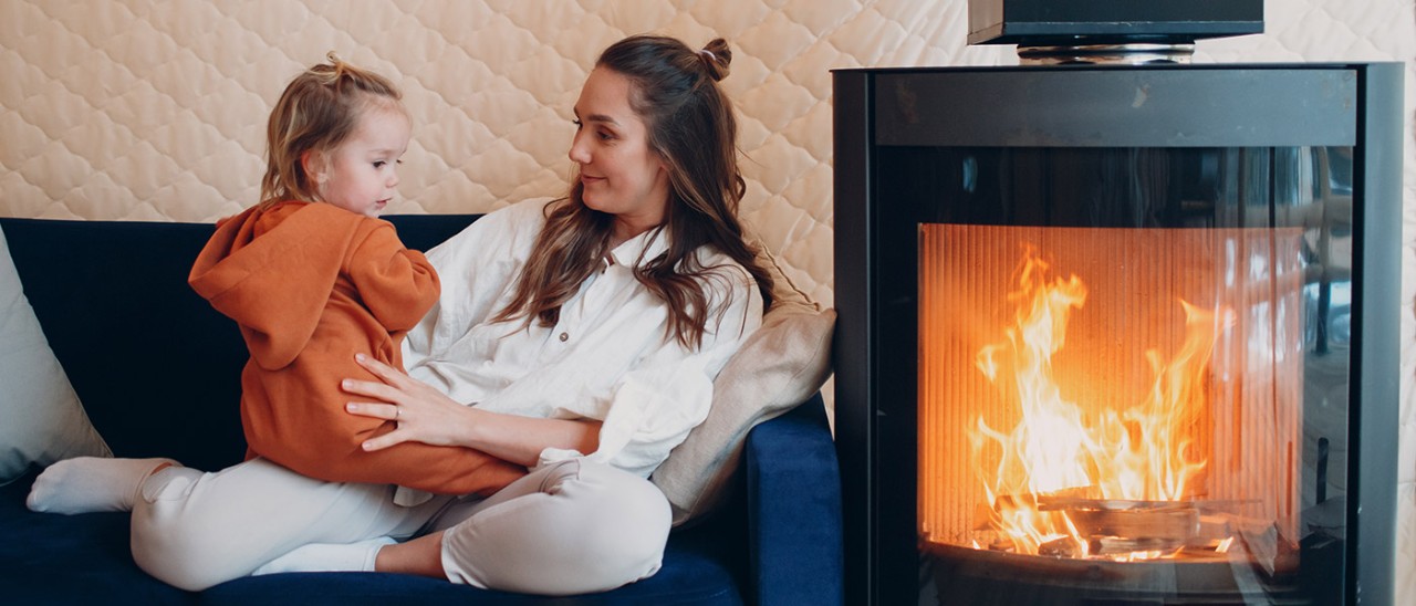 fireplace-family-Getty-1340367379-1400x600.jpg Mother and daughter on sofa next to fireplace