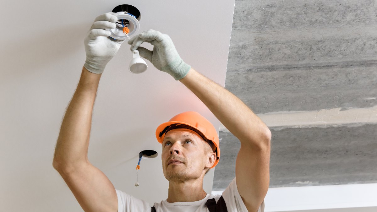 electrician changing lightbulb