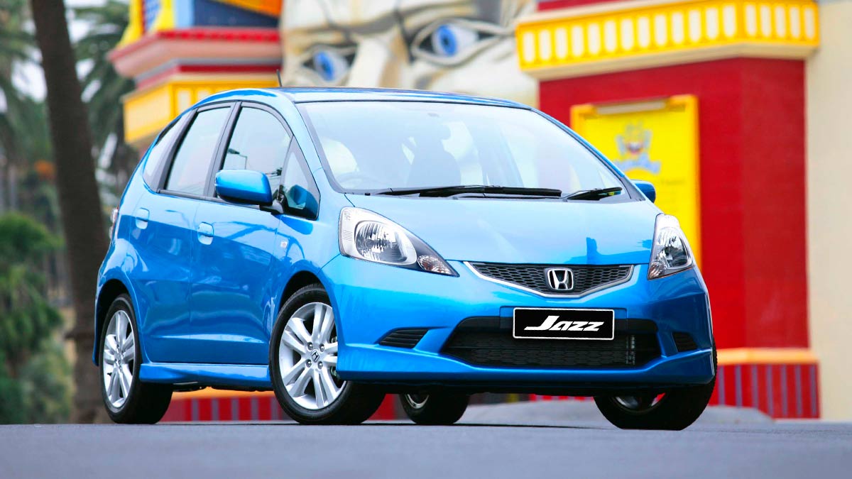 Front side view of a blue Honda Jazz parked in front of the Luna Park entrance