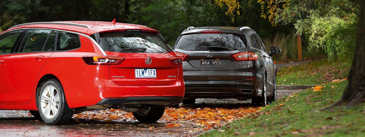 Rrear of red Holden Commodore parked next to the rear of a grey Ford Mondeo