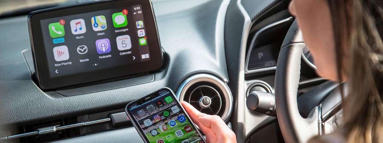 Person connecting their mobile phone to their car's infotainment system.