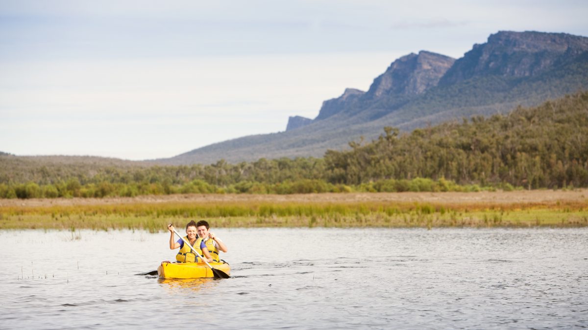 couple canoeing on a lake with mountain in background