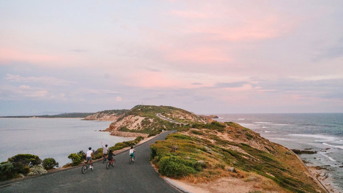 family riding bikes on coast